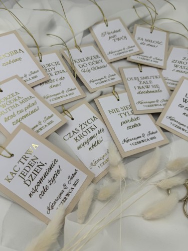 Zbliżenie na złote litery na beżowej zawieszce