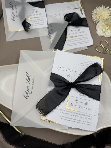 białe zaproszenie ślubne B6 z czarną kokardą i z płatkami złota