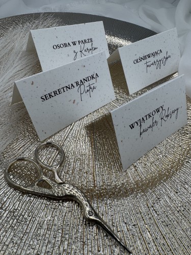 Winietka ślubna stojąca na stole weselnym przy nakryciu