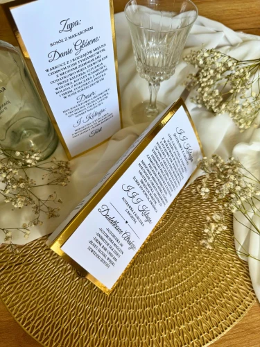 Rzut z góry na menu ślubne trójkątne personalizowane z złotą ramką
